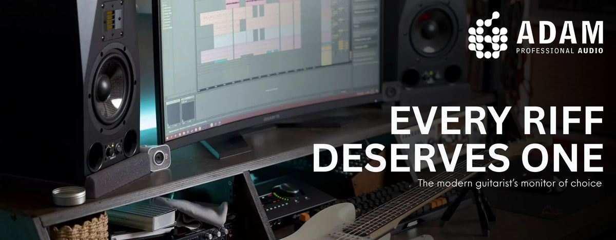 ADAM Audio hero banner: ADAM studio monitors beside a curved screen, audio interface and electric guitar on a home-studio desk, "Every riff deserves one - the modern guitarist’s monitor of choice"
