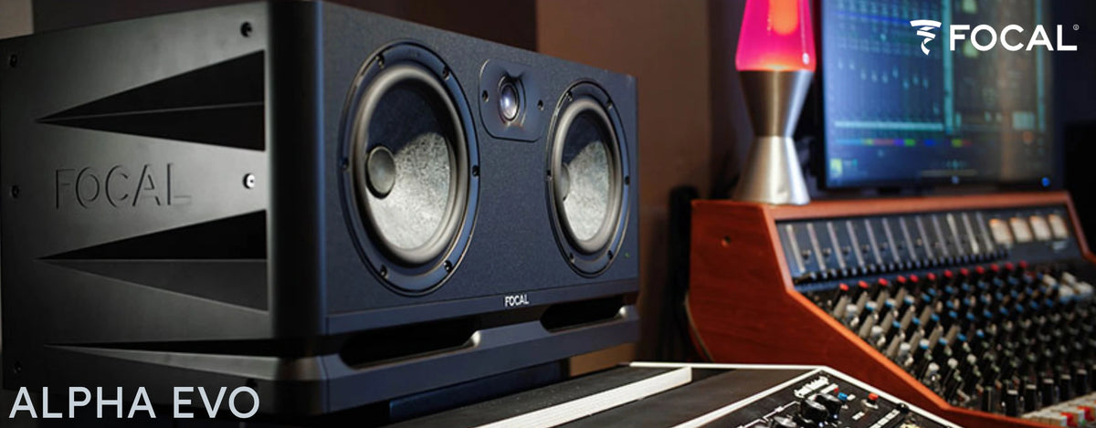 Focal Alpha Evo studio monitor close-up in a recording studio beside a mixing console, lava lamp and DAW screen